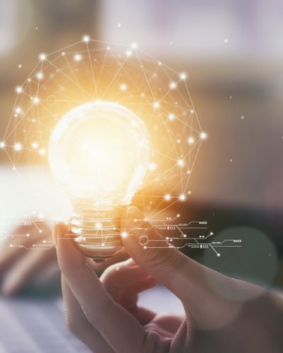 Hand holding light bulb with innovative and creativity are keys to success. Concept knowledge leads to ideas and inspiration.